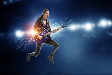 Young and beautiful rock girl playing the electric guitar - 737651639