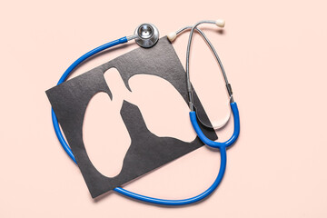 Paper cut out lungs and stethoscope on beige background