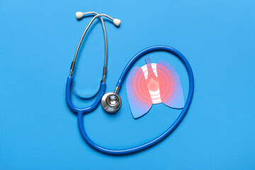Paper lungs with stethoscope on blue background