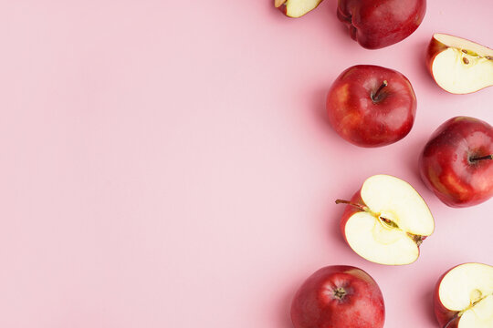 Many fresh red apples on pink background