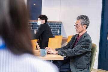 カフェで仕事をする中年男性