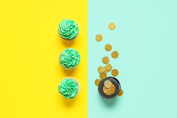 Tasty green cupcakes with pot of golden coins for St. Patrick's Day on color background