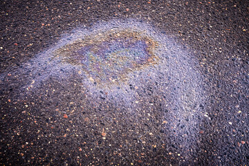 A bright spot of oil or gasoline spray on the pavement after rain. Oil stain on the asphalt,...
