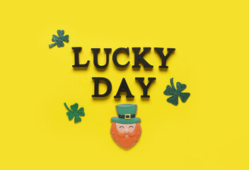Words LUCKY DAY with gingerbread cookie and clovers for St. Patrick's celebration on yellow...