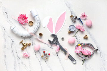 Composition with plumber's items, Easter eggs and flowers on light background