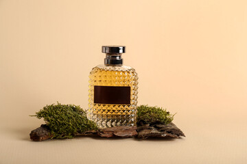 Bottle of perfume with moss on beige background