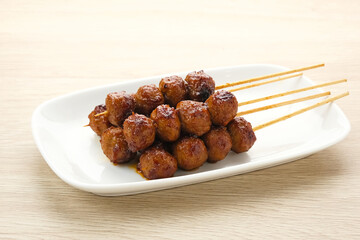 Grilled meatballs skewers with teriyaki sauce
