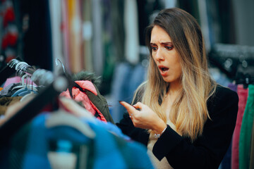 Surprised Customer Checking the Inflated Price Tag on Clothing. Overwhelmed shopper having a...