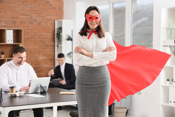 Young businesswoman dressed as superhero in office © Pixel-Shot