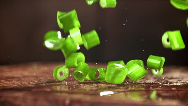 The chopped green onions fall onto the cutting board. Filmed on a high-speed camera at 1000 fps. High quality FullHD footage
