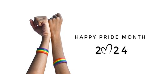 Happy Pride Month 2024 on rainbow wristbands wearing in hands raising background, concept for...