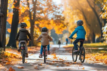 Fotobehang Young family bike riding in sunny autumn park © Esha