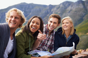 Obraz premium Happy people, friends and pointing with map for travel, location or destination on mountain in nature. Young group with smile, document or geographic paper for navigation, help or outdoor tourism