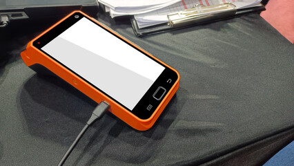 Side View Orange and Black color Cash card machine on black table background, technology, money, object, fast, cash, copy space