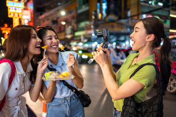 Asian young women vlogger use camera record vlog while travel in city.