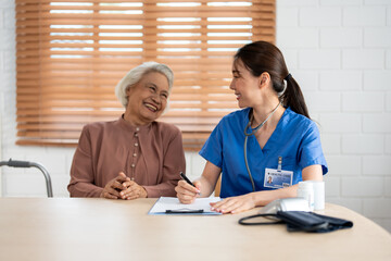 Asian young caregiver nurse examine senior woman patient at home. 