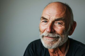 Portrait of a senior man with grey hair and beard looking at the camera.