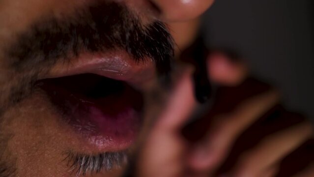 Macro Shot of a asian man's mouth engaged in conversation, highlighting the portrayal of facial expressions, gestures, and communication.
