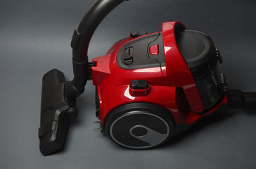 Red modern vacuum cleaner on dark gray background