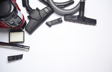 Components and attachments of a modern vacuum cleaner on white background. Top view. Copy space