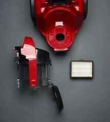 Components and attachments of a modern vacuum cleaner on dark background. Top view. Flat lay