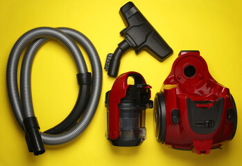 Components and attachments of a modern vacuum cleaner on yellow background. Top view. Flat lay