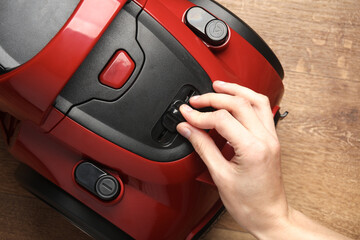 Hand adjusts the power of the vacuum cleaner