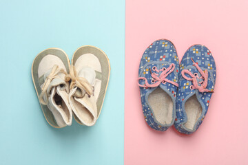 Children's used shoes on pink blue background