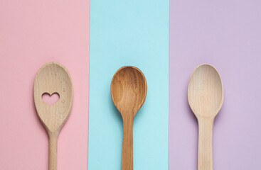 Natural wooden spoons on a colored background