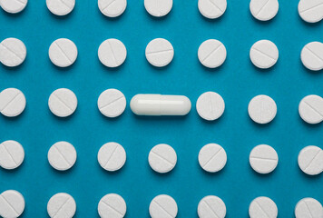 Group of white pills on a blue background. Medicine concept