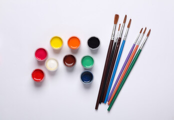 Set of gouache paints in bottles with brushes on a white background. Children's creativity