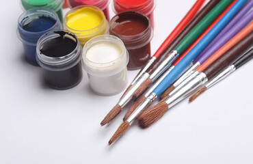 Set of gouache paints in bottles with brushes on a white background. Children's creativity