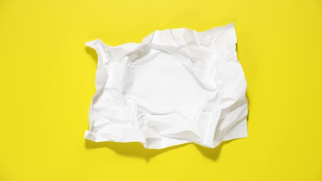 Stop motion animation of crumpled paper, stop motion animation 4k, on a yellow background.