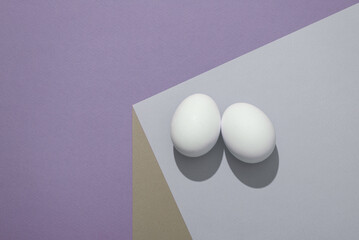 Eggs on a paper cube. Optical illusion. Food concept. Geometric composition. Minimalistic creative layout