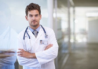 Doctor, man and portrait with arms crossed in hospital with healthcare for wellness, medicine and stethoscope by window. Medical, professional and expert with face for diagnosis, health and service