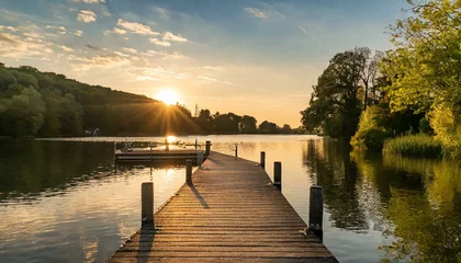 Foto op Canvas sunset over the lake wallpaper pier jetty golden hour sunset on lake, trees in background landscape © Ali