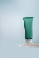 Shampoo in a tube stands on a glass shelf. Green tube with hair mask. Mockup. Hair conditioner moisturizing and nourishing