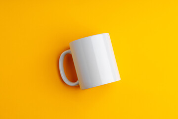 Ceramic mug on yellow studio background close up