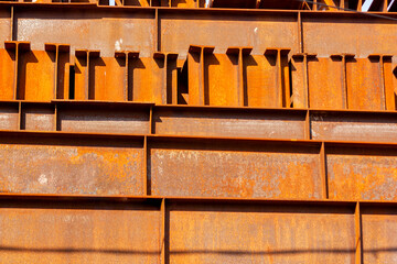 metal rusty sleepers lie in a large stack in a warehouse close-up