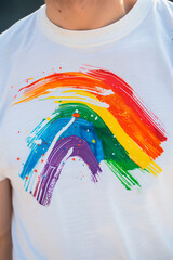 Young man wearing a white t-shirt with a hand-painted rainbow flag. Gay Pride's day - obrazy, fototapety, plakaty