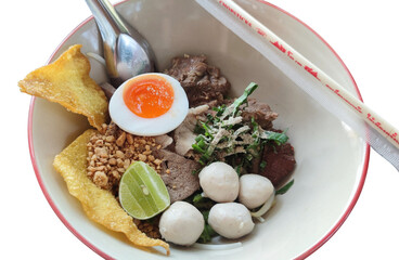 Picture of thin dry thai noodles with tom yum and boiled eggs.