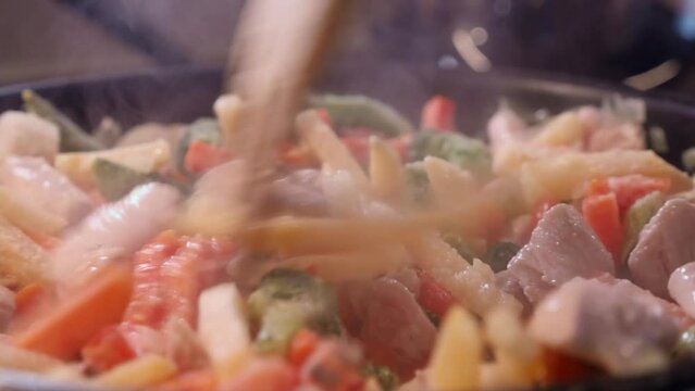 Close up: Chicken and vegetables steaming, cooked in hot saucepan