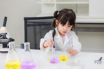 Obraz na płótnie Canvas Asian little cute girl students in lab coat making test tube science experiments chemical laboratory in study room at school. Education research and development concept learning kids.