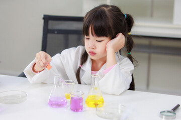 Obraz na płótnie Canvas Asian little cute girl students in lab coat thinking making test tube science experiments chemical laboratory in study room at school. Education research and development concept learning kids.