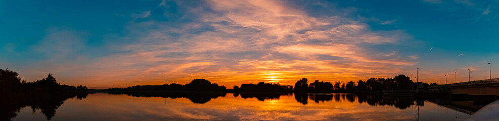 High resolution stitched summer sunset panorama with reflections near Plattling, Isar, Bavaria, Germany