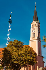 Church and a maypole on a sunny summer day at Plattling, Isar, Deggendorf, Bavaria, Germany