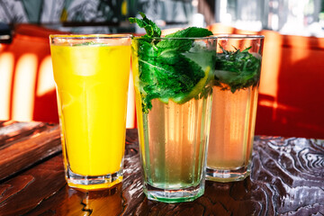 Three glasses of lemonade on a table in a street cafe.