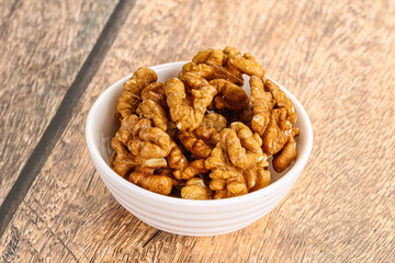 Cracked unshelled walnut in the bowl