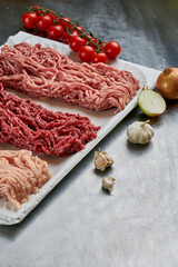 Assorted fresh minced meat from different types of meat in a butcher shop on a tray