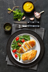 fried chicken breasts with green salad on plate